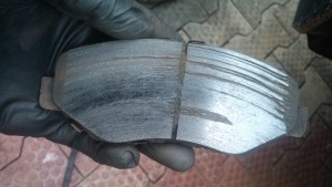 My brake pad with erosion, glazing and grooves.